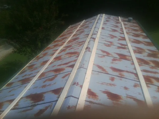 Rusted metal roof panels with new wood purlins before replacement — Storm Damage Roof Repair in Clarendon Hills by Roofing Brothers