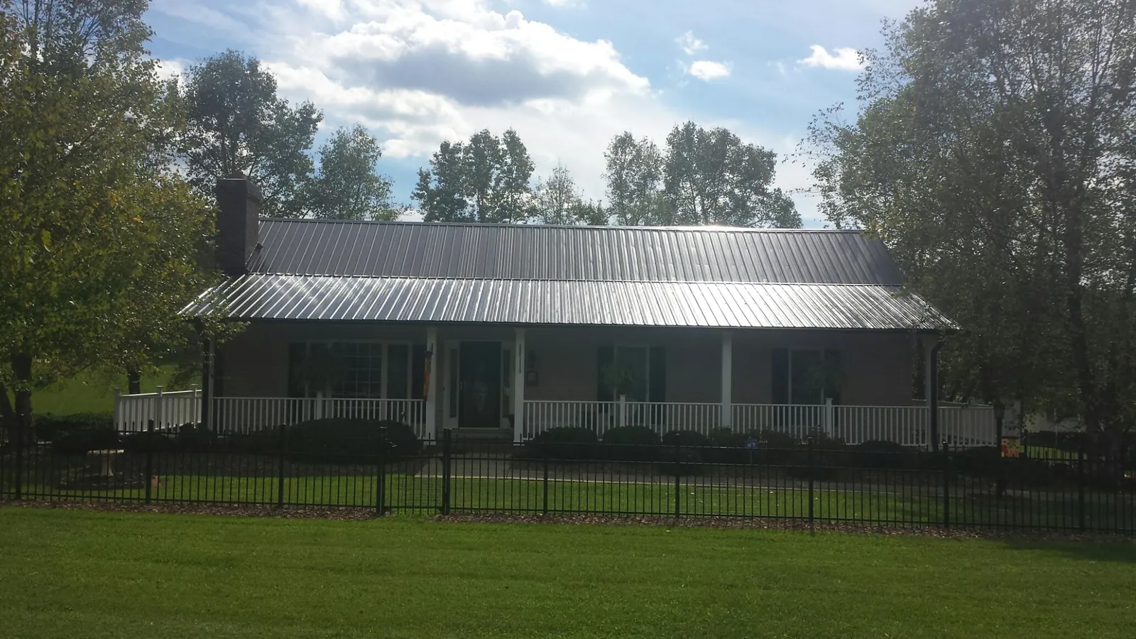 Gray metal roof on a brick ranch with a full width front porch — Gutter Guard Installation work by our crew in Clarendon Hills