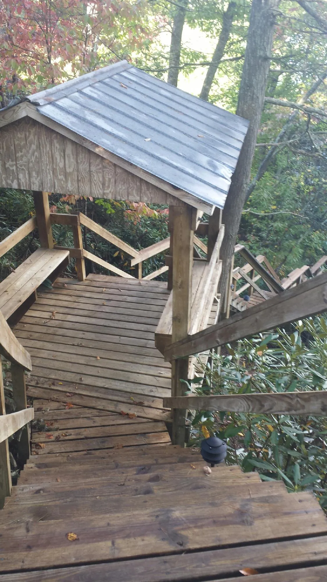 Metal roofed shelter over wooden steps on a wooded walkway — Skylight Repair & Installation work by our crew in Clarendon Hills